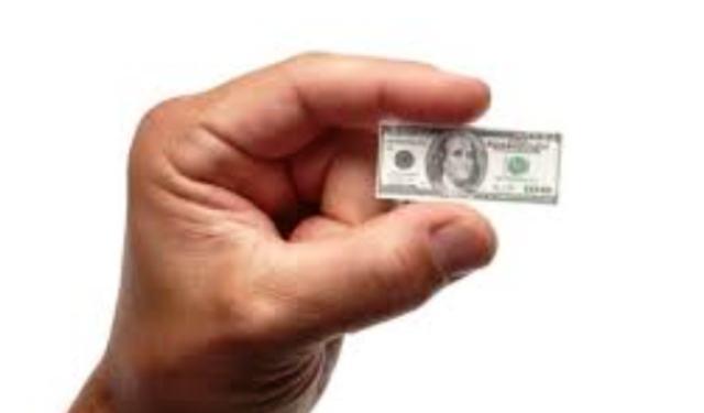 currency devaluation depicted by small dollar large hand